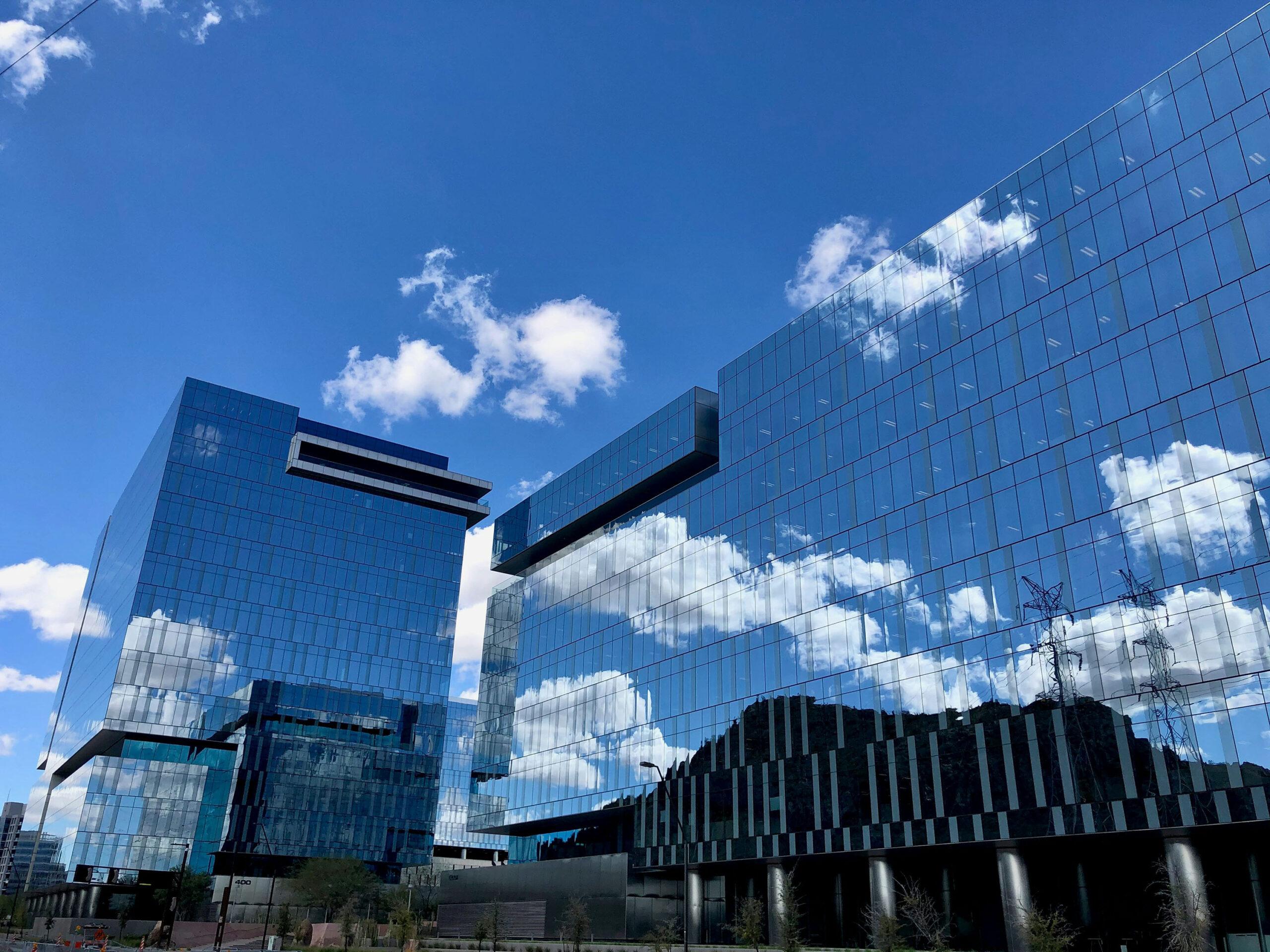 The State Farm office buildings reflecting the sky above them.